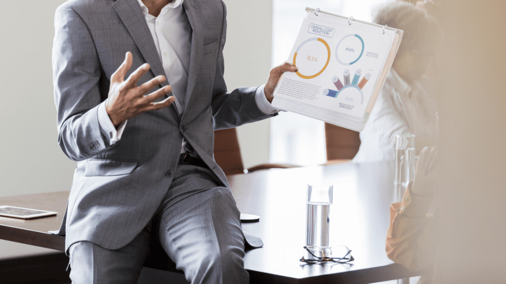 A professional man holding a poster explaining or presenting in a business setting.